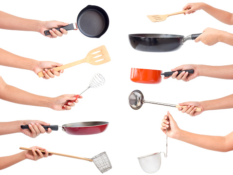 Las manos del chef con utensilios de cocina / muchos equipos para alimentos aislaron sobre fondo blanco photo