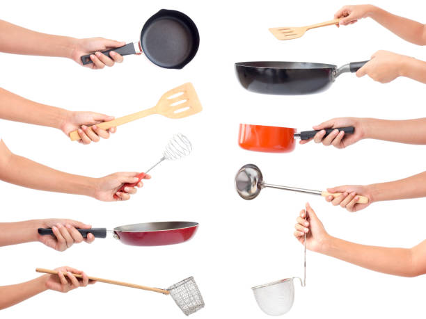 Chef's hands holding kitchen utensils/many equipment for food isolated on white background