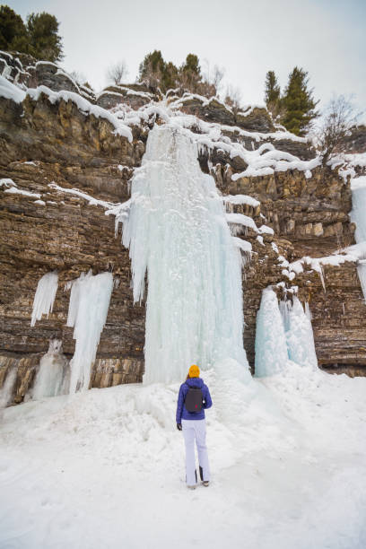 Frozen Waterfall Girl My wife in front of this frozen waterfall near Big Sky, Montana shows just how massive it really was. big sky ski resort stock pictures, royalty-free photos & images