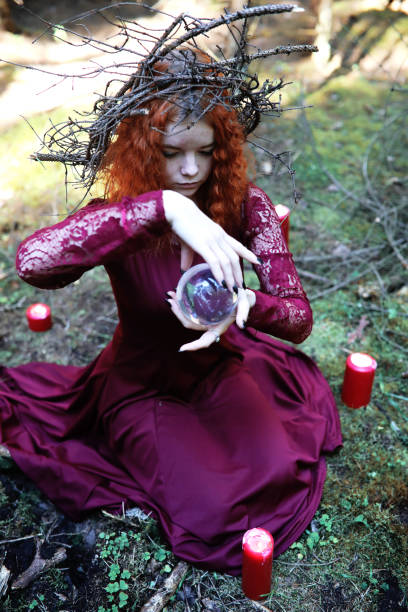 istock The red-haired witch holds a ritual with a crystal ball 903164160