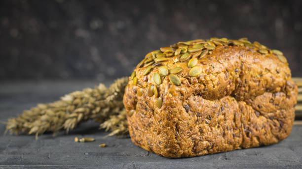 istock Ears of wheat next to the bread flour on a dark table. 903169202