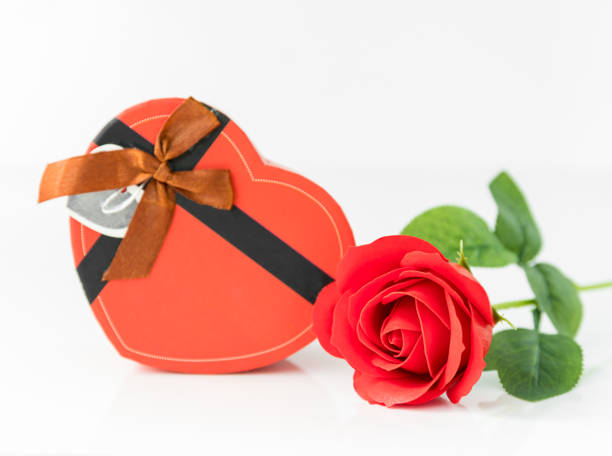 istock Close up red rose and heart-shaped box on white 903176658