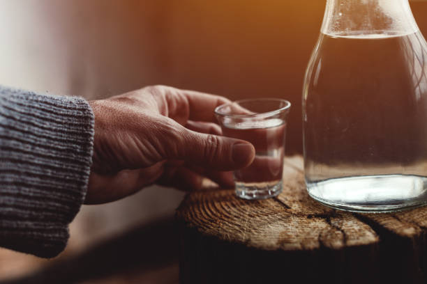Man drinking strong alcohol drink from a shot glass Man drinking strong alcohol drink from a shot glass, close up of hand, selective focus serbian raki stock pictures, royalty-free photos & images
