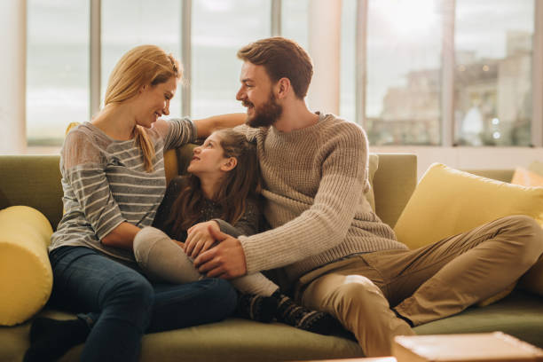 istock Young happy family communicating while relaxing on sofa at home. 903191106