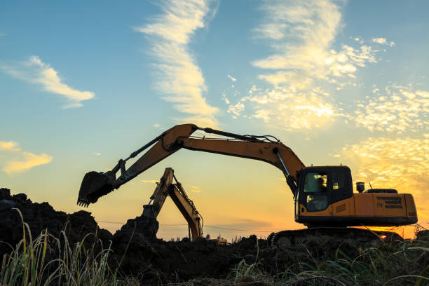 istock excavator working on construction site and sunrise landscape 903195028