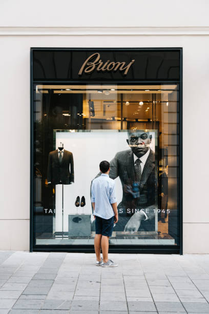 jovem em frente a loja de moda de luxo - brioni - fotografias e filmes do acervo