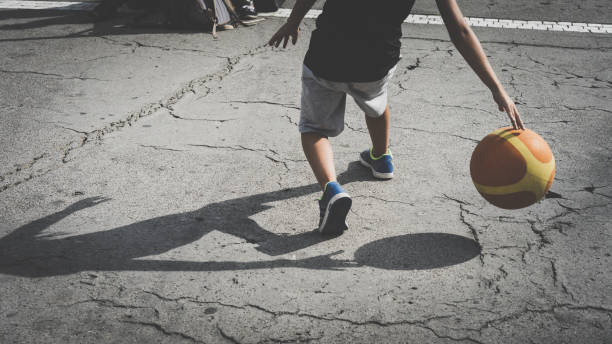 istock Low Section Of Men Playing With Ball On Street 903195864