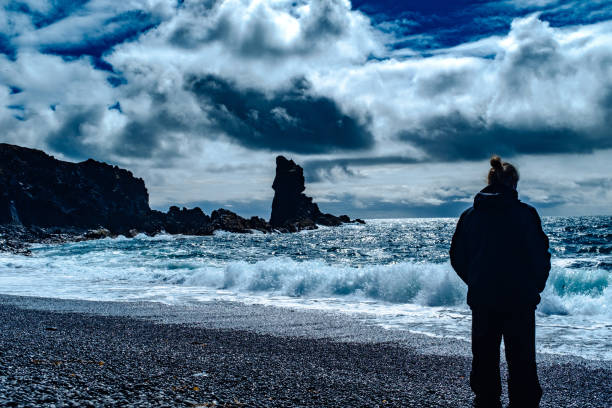 istock Woman Standing On Shore At Beach Against Sky 903195882