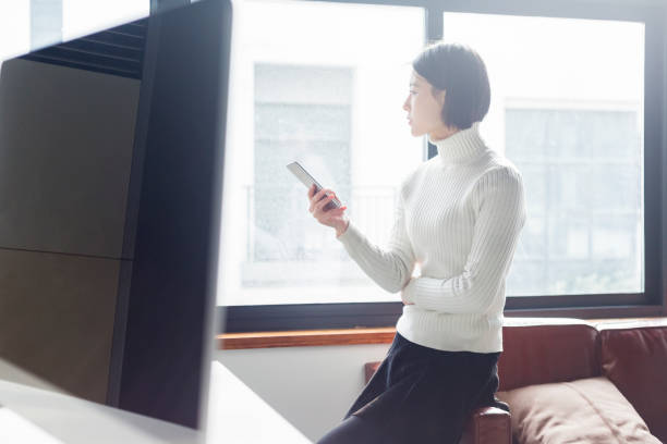 istock portrait of young woman using phone by window 903203100