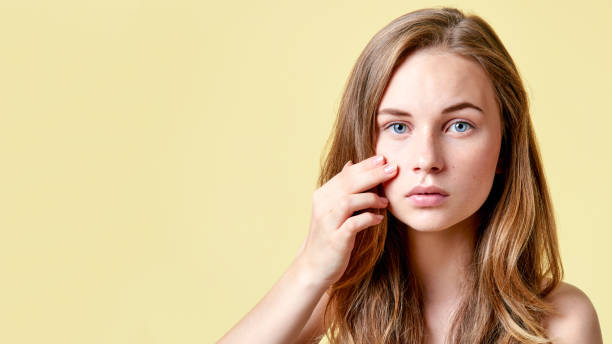 istock Young redhead teenager with self issues looking into mirror. Girl with low self esteem checking her skin in a mirror. 903214374
