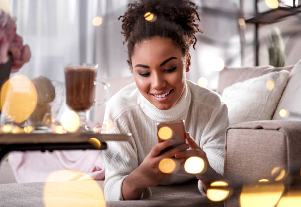 istock Happy african woman using mobile phone at home 903217846