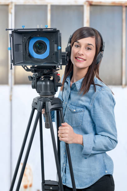 istock beautiful young woman with DSLR video camera 903217976