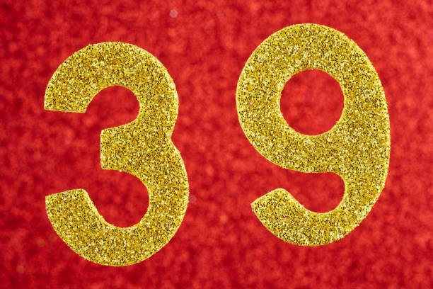 istock Number thirty-nine gold color over a red background. Anniversary 903218060