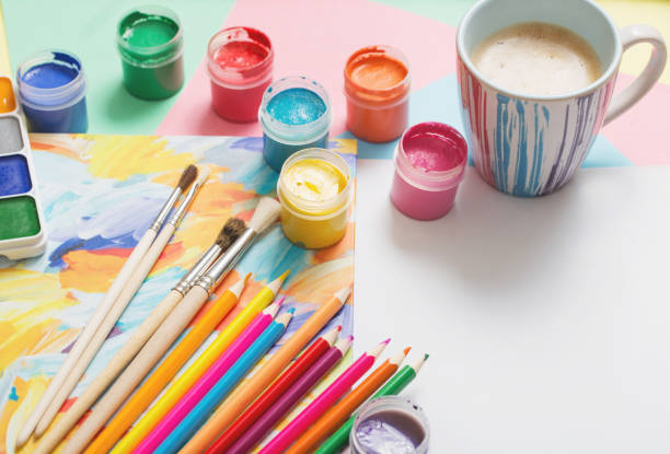 istock cup of coffee and paints, pencils on white background 903221220