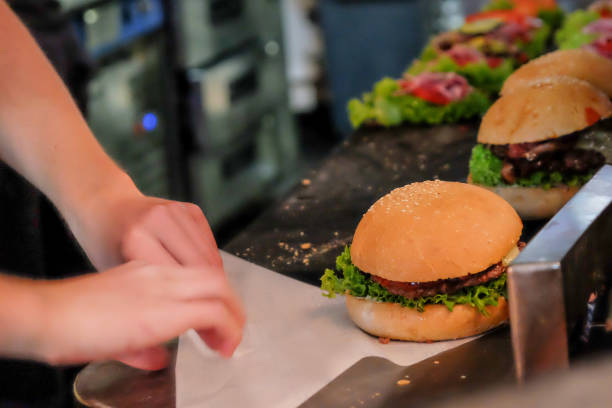 Grand chicken patty fillet burger topped with delicious sauce, fresh tomatoes, crispy lettuce, fresh onions and slices of Emmental cheese served in a fresh sesame bun, selective focus