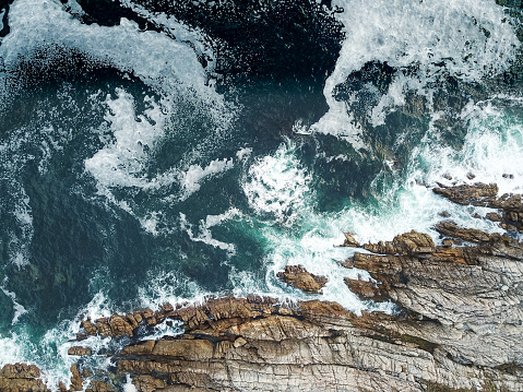 A high angle view of waves crashing against the rocks near the cost of Cape Town, South Africa