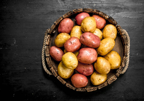 istock Fresh potatoes in an old wooden tray. 903229388