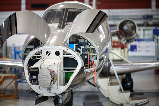 Jet airplane in the hangar opened for regular maintenance service.