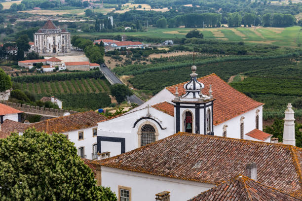 Santiago Church Obidos Portugal Santiago Church, the typical houses roofs and Senhor da Pedra sanctuary in Obidos historical medieval city, Portugal. obidos photos stock pictures, royalty-free photos & images