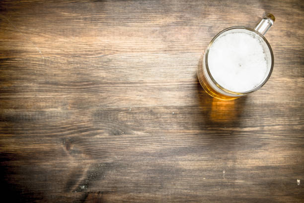 istock mug of fresh beer. On wooden table. 903234096