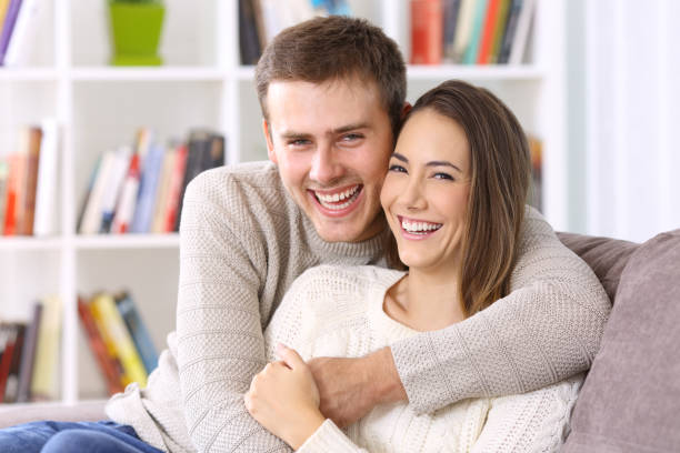 couple heureux avec le sourire parfait vous regarder - dentists chair people care medical equipment photos et images de collection