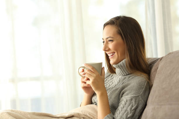 istock Pensive woman holding a coffee mug relaxing at home 903242300