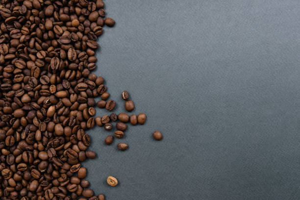 어둠 속에 커피 콩 회색 배경, 절반 - tamping 뉴스 사진 이미지