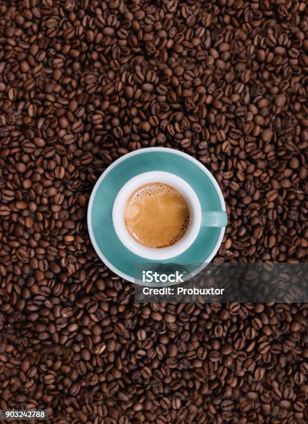 Delicious Fresh Morning Espresso With A Beautiful Crema In A Ceramic Green Cup With A Saucer On The Coffee Beans Background Top View Stock Photo - Download Image Now