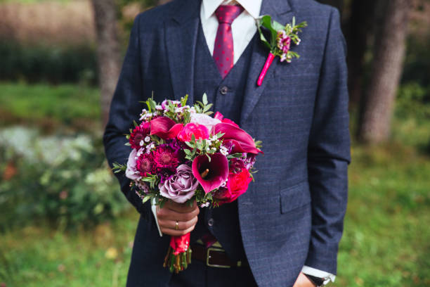 istock Elegant groom in costume and bow-tie with bouquet . 903246042