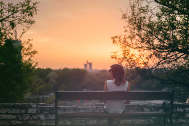 istock Woman sitting on a bench and watching the distant city scenery. 903246306