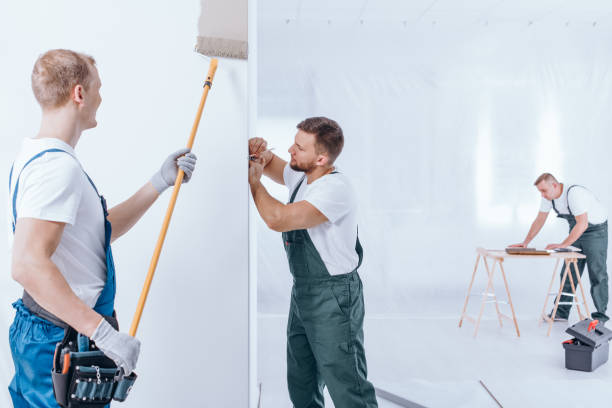 istock Painter with gloves painting wall 903249484