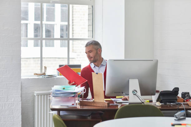 istock Confident businessman with some documents at office desk 903250140