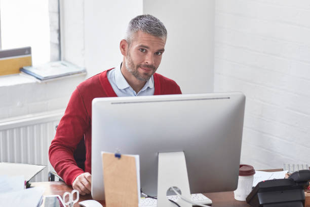 istock Portrait of confident businessman using computer at office 903256550