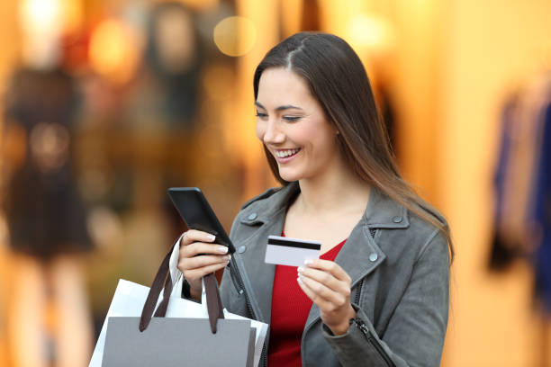 istock Shopper paying on line with credit card in a mall 903257844