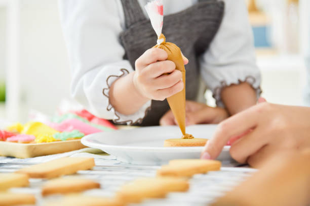 istock Happy Asian Kid decorating cookies. 903261358