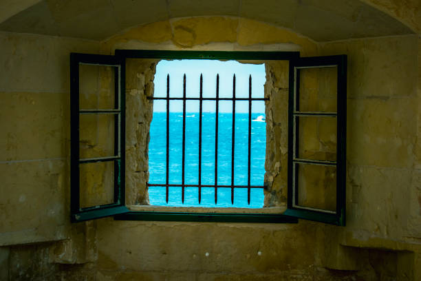 view through a prison window in a historical site on saint Elmo fort Malta Valletta view through bars window