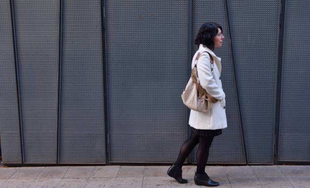 istock woman walking next to an iron texture wall 903264662