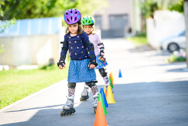 istock Children learning to roller skate on the road with cones. 903265922
