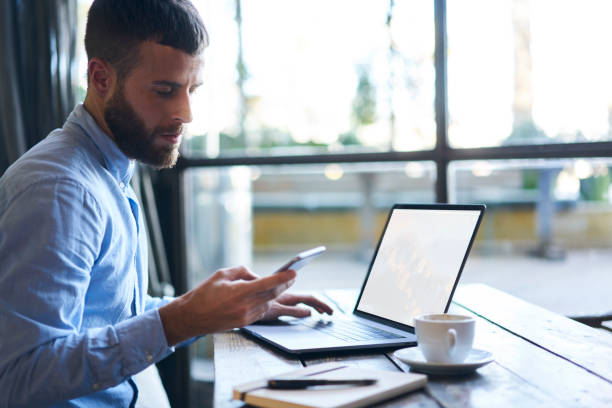 istock Young bearded businessman reading received sms message from colleague while working at modern laptop computer with copy space area for your advertising text message and sitting in loft interior 903266422