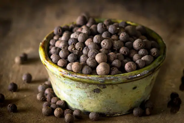 Photo of Allspice on rustic background
