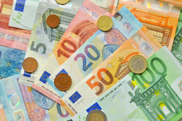 istock Euro coins over paper euro banknotes. 903273494