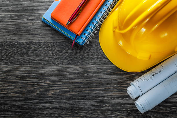 istock Construction drawings building helmet notepads pen on wood board 903273716