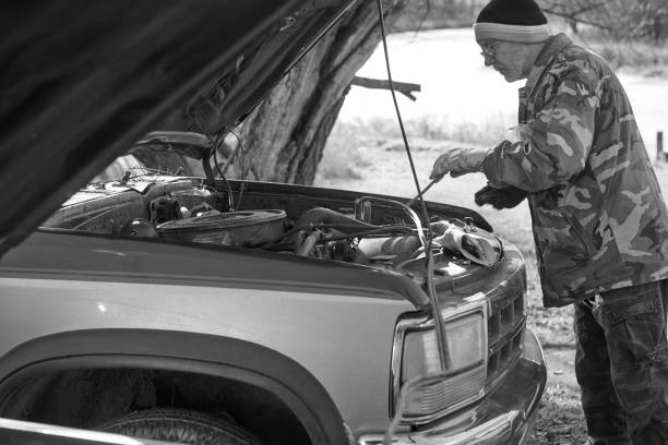 istock Man trying to start car with battery charger 903281588