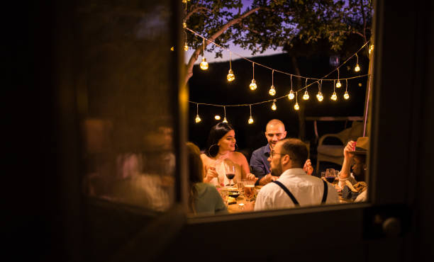 Young multi-ethnic friends having rustic dinner party in countryside Young multi-ethnic friends on summer holidays celebrating and having dinner at rustic countryside cottage plus size woman fashion laughing stock pictures, royalty-free photos & images