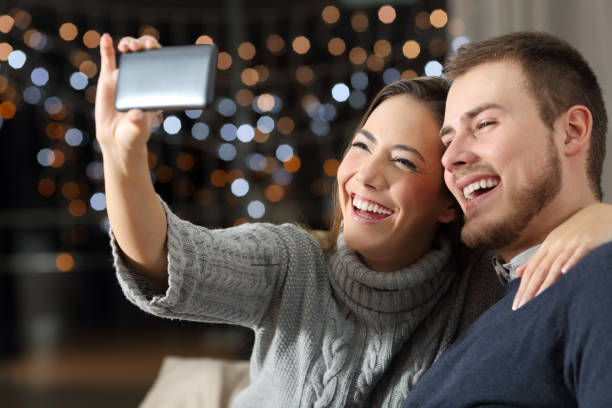 istock Couple taking selfies in winter at home 903282716