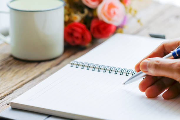istock male hand writing in notebook with pen 903289672