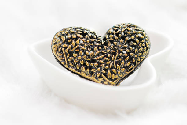 Valentine's day concept - Black heart jewellery pendant on white background.