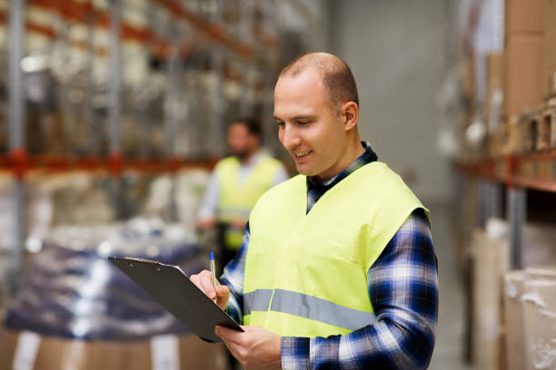 istock man with clipboard in safety vest at warehouse 903297320