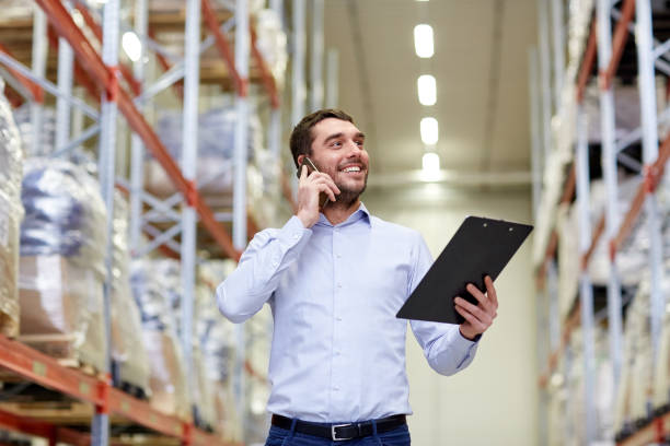 istock man with clipboard and smartphone at warehouse 903298506
