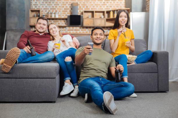 istock Young smiling people sitting together and watching TV 903298788